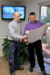 Mark Jones, drafting supervisor at Nucor Vulcraft-SC (on the left), checks the work of Dean Mann, a 2015 graduate of Florence-Darlington Technical College. Mann is one of two 2015 spring interns from the two-year college to receive a full-time job offer from Nucor.