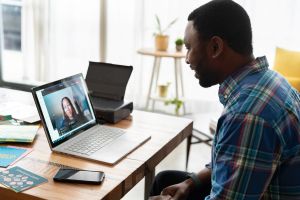 A person looking at another person over the computer screen