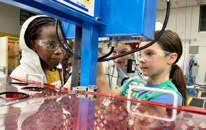 A BCTC instructor explains lockout-tagout procedures to middle school students during a Girls Can, Too! workshop.