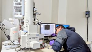 A student loads samples into a scanning electron microscope at the Micron-Norfolk State University cleanroom. 